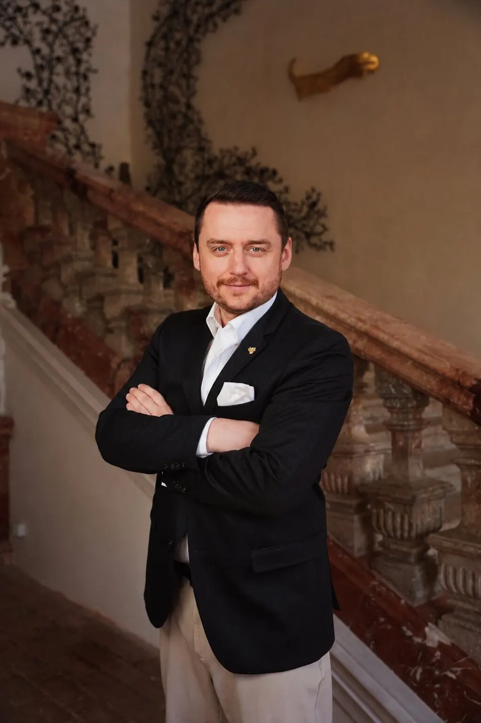 Bernhard Kick im dunklen Sakko mit verschränkten Armen